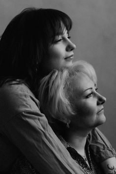 black and white photograph of two women with one holding the other's back while looking off into the distance