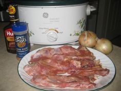 some meat is sitting on a plate next to an instant pot roaster and garlic