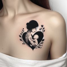 a woman with a tattoo on her shoulder holding a baby in the shape of a heart