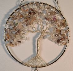 a tree of life with many different colored stones hanging from it's metal frame