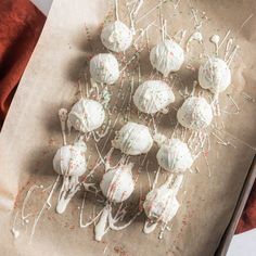 white cake pops with sprinkles are on a piece of parchment paper