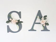 the letters are made out of wood and have flowers on each letter's sides