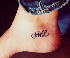 a woman's foot with a small tattoo on the ankle that reads m and l