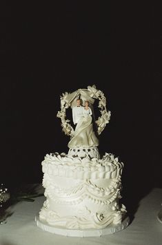 a wedding cake with a bride and groom figurine on top