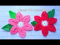 two crocheted flowers sitting on top of a brick wall