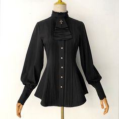 A pleated blouse that looks like an aristocratic lady from medieval Europe. It has a pleated chest and a removable cravat decorated with a cross. The cuffs are long and the waist is tapered. For a young lady with a noble atmosphere. 
 
 

 

 
 
 Color 
 
 Black 
 White 
 Red 
 Light brown 
 
 
 Size 
 
 
 S size 
 
 Length: 63-68cm 
 Shoulder width: 36cm 
 Bust: 86cm 
 Waist: 70cm 
 Sleeve length: 60cm 
 
 M size 
 
 Length: 64-69cm 
 Shoulder width: 37.5cm 
 Bust: 92cm 
 Waist: 76cm 
 Sleeve l Long Sleeve Gothic Blouse For Formal Occasions, Gothic Formal Tops For Fall, Black Gothic Blouse For Formal Occasions, Formal Gothic Long Sleeve Blouse, Gothic Formal Tops With Ruffles, Gothic Fitted Tops For Workwear, Formal Pleated Long Sleeve Blouse, Gothic Long Sleeve Blouse For Fall, Fitted Pleated Blouse For Formal Occasions