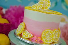 a pink and yellow cake with lemons on top