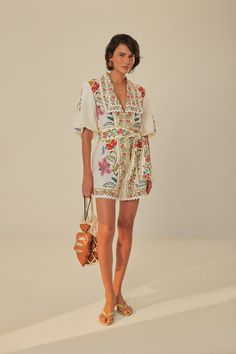 Step into the enchanting world of the Off-White Floral Insects Romper by FARM Rio. This delightful piece captivates with its lively tapestry of florals and fluttering insects, a colorful ode to nature's beauty. Framed by a collar neckline and flared sleeves, the romper creates a relaxed yet refined silhouette, cinched at the waist for an effortlessly feminine flair. Delicate lace trimmings dance along the hems, adding a touch of whimsy to your every move. An exquisite ensemble for days under the sun and balmy evenings alike. Composition 55% LINEN 45% VISCOSECare Instructions MACHINE WASH GENTLE CYCLE, DO NOT BLEACH, DO NOT TUMBLE DRY, LINE DRYING, IRON AT LOW HEAT, DRY CLEAN WITH ANY SOLVENT EXCEPT TRICHLOROETHYLENESize and Fit Inches XXS XS S M L XL Bust 35 37 39 41 44 47 1/4 Waist 34 3/4 Horse Race Outfit, Brazilian Clothes, Race Outfit, Bird Scarf, White Romper, Belt Style, Farm Rio, Floral Romper, Flared Sleeves