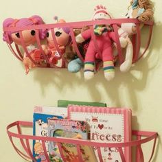 there is a shelf with dolls and books on it, along with pictures of children's toys