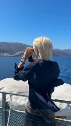 a woman taking a photo on the back of a boat