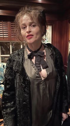 a woman in a black dress and bow tie