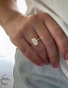 a woman's hand with a diamond ring on her left hand and the other hand holding