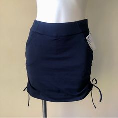 Cinch Sides Mini Skirt Skort By Nicole Miller New York - A Great Modern Piece For The Golf Course, Tennis Court, Or Wherever Your Active Lifestyle Takes You! Features A Fun Sporty Look With Ruched Side Seams And Tie Accents (Allows You To Adjust Length To Your Liking) Wide Covered Elastic Pull-On Waistband Two Side Slant Pockets Super Soft Knit Material With Active Stretch Soft & Silky Knit Short Lining Polyester/Spandex Machine Wash Imported Navy Size Xs Approx Flat Waist 13", Length (Adjustabl Blue Stretch Bottoms With Ruched Sides, Fitted Ruched Bottoms For Workwear, Casual Mini Bottoms With Drawstring, Casual High Waist Elastane Skirt, Casual High-waist Elastane Skirt, Casual Workwear Skirt With Gathered Waist, Fitted Swim Skirt With Pockets, Chic Skirted Bottoms With Gathered Waist, Casual Ruched Mini Skort