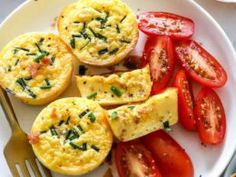 scrambled eggs and tomatoes on a plate with a fork