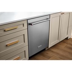 a dishwasher is sitting in the middle of a kitchen with white cabinets and wood flooring