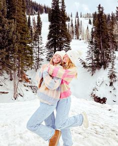 two women hugging each other in the snow