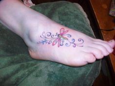 a woman's foot with a flower tattoo on it