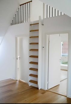 an empty room with stairs and hard wood flooring