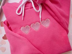 Introducing our vibrant and stylish Gamer Hoodie with Embroidered Pixelated Hearts! The soft and high-quality fabric ensures a luxurious feel against your skin, making these comfortable enough to wear all day long.  BELLA CANVAS HOODIE Unisex sizing. White cord drawstrings. Pouch pockets. Ribbed cuffs and waistband. 52% cotton, 48% polyester WASHING INSTRUCTIONS  -Turn clothes inside out -Machine wash cold only -Do not iron design (may iron on reverse side) -Do not use bleach -Tumble dry on low Gamer Hoodie, Gifts For Gamers, Kawaii Sweater, Pink Games, Gaming Hoodie, Gamer Gifts, Cute Sweaters, Style Expert, Girls Sweaters