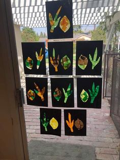 several pieces of paper cut out to look like leaves and flowers on a window sill