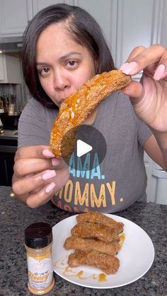 a woman holding up a piece of bread to her face