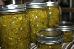 several jars filled with pickles sitting on top of a table