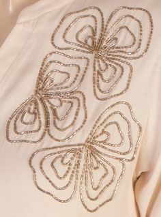 a white shirt with gold sequins on it