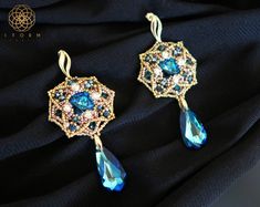 Romantic, lace-like beaded earrings using bermuda blue Swarovski stones as focal cabochons that are embellished with Swarovski montees DIMENSIONS Width : 1 1/2 inch // 3.5 cm Length including drop : 3 inch // 8 cm DELIVERY Your purchase will be delivered via registered mail in bubble wrapped envelope/ in mailing box to the address registered with Etsy. If you prefer to have it delivered to an alternative address, please add the delivery address in the Note section at checkout. Insurance and cour Elegant Beaded Earrings With Bead Caps For Wedding, Elegant Handmade Crystal Beaded Earrings, Handmade Elegant Crystal Beaded Earrings, Elegant Blue Beaded Earrings, Byzantine Earrings, Beaded Necklace Tutorial, Blue Beaded Earrings, Soutache Necklace, Swarovski Stones