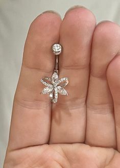 a person is holding an open ring with a flower on it