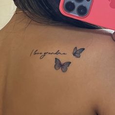 the back of a woman's shoulder with two butterflies on it, and an inscription in cursive writing