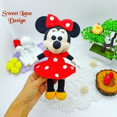 a crocheted minnie mouse doll is displayed on a doily with other decorations