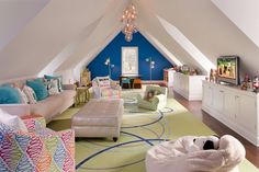 a living room filled with lots of furniture and colorful rugs on top of a hard wood floor