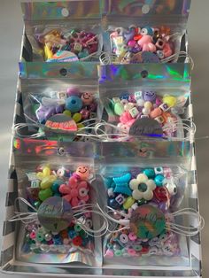 several clear plastic boxes filled with different types of buttons and magnets on white background