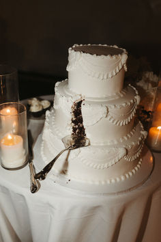 a wedding cake with candles on the table