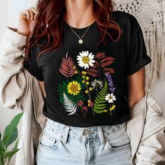 Embrace the beauty of nature with this Floral Boho T-shirt - a must-have addition to any spring floral clothing collection! Featuring a mix of colourful wildflowers and botanicals , this aesthetic shirt is perfect gift for nature and garden lover **US based customers: Your order will be shipped from US** This unisex soft-style T-shirt is classic fit with the crew neckline, made from very soft materials,100% cotton for solid colors (heather colors and sports grey - blend of cotton and polyester). Black T-shirt With Sunflower Print For Spring, Nature-inspired Summer Tops With Plant Print, Nature-inspired Tops With Plant Print For Summer, Summer Nature-inspired Tops With Plant Print, Black Graphic Tee With Plant Print, Black Graphic Tee With Plants Print, Casual Black T-shirt With Plant Print, Black Summer Tops With Plant Print, Black Botanical Top For Spring