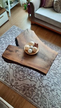 a wooden table sitting on top of a rug in a living room next to a couch