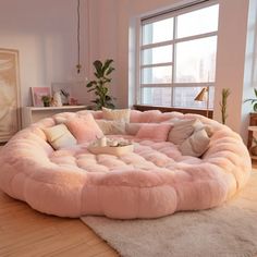 a living room filled with lots of furniture and pillows on top of a wooden floor