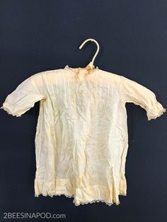 an old white shirt hanging on a black wall