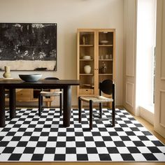 a black and white checkered floor in a dining room with two chairs at the table