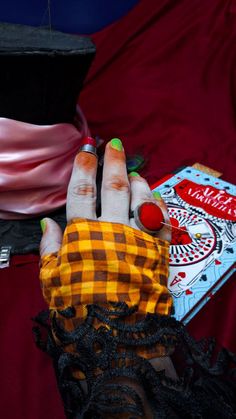 a woman's hand with painted nails and manicures on it, next to a book