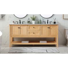 a white toilet sitting next to a wooden sink vanity with two mirrors on the wall