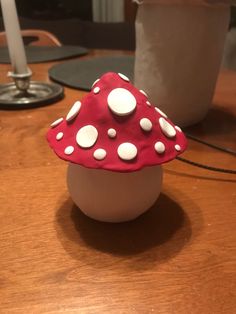 a red and white mushroom sitting on top of a wooden table