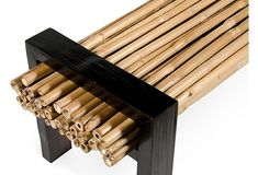 a bench made out of bamboo sticks and black slats on the bottom, along with two legs