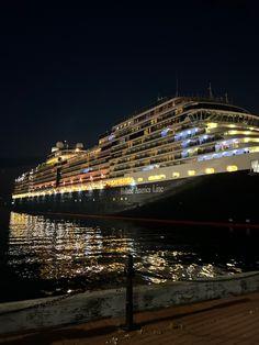 a large cruise ship is docked at night