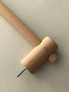 a wooden handle with screws attached to it on a white surface, next to a pair of scissors