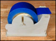 a blue tape dispenser sitting on top of a wooden table