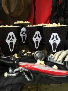 three halloween treat bags with scary faces on them and a knife in front of them