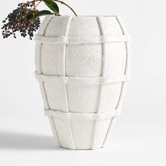 a white vase with a plant in it