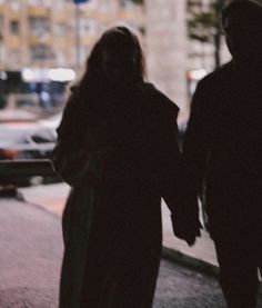 two people walking down the street holding hands