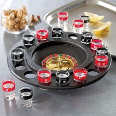 a casino wheel with cups and shots on the table